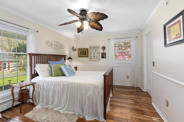 bedroom featuring ornamental molding, a baseboard radiator, ceiling fan, and wood finished floors