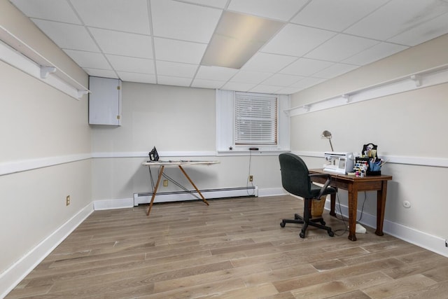 home office featuring baseboards, light wood finished floors, a drop ceiling, and baseboard heating