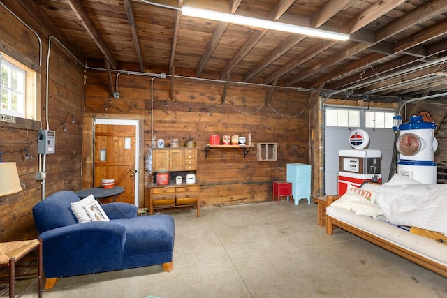 basement with a garage, visible vents, wooden walls, and a healthy amount of sunlight