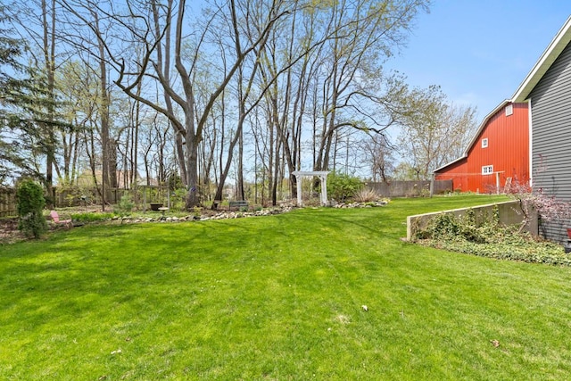 view of yard with a barn, fence, and an outdoor structure