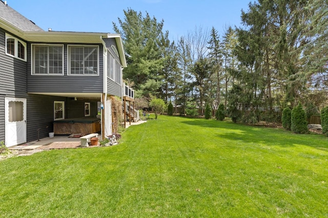 view of yard with a hot tub, a fenced backyard, and a patio area