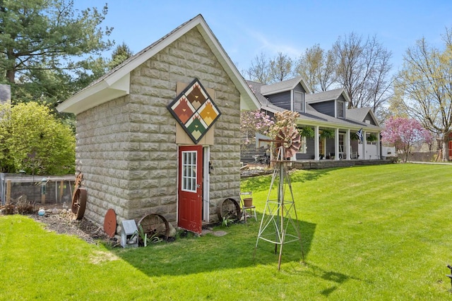 view of outdoor structure with a porch and an outbuilding