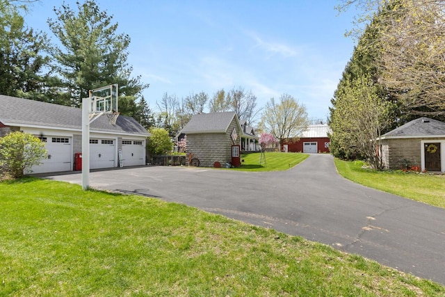 exterior space featuring a yard, an outdoor structure, and a detached garage