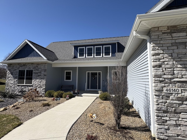 46140 Finch St, Mattawan, MI 49071 - property entrance with board and batten siding, roof with shingles, covered porch, and stone siding