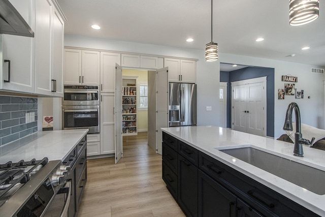 46140 Finch St, Mattawan, MI 49071 - kitchen featuring a sink, dark cabinetry, light stone countertops, and stainless steel appliances