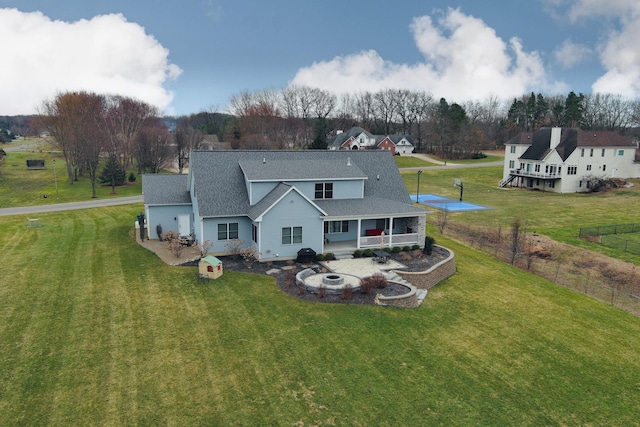 46140 Finch St, Mattawan, MI 49071 - back of house featuring a lawn, a shingled roof, and an outdoor fire pit