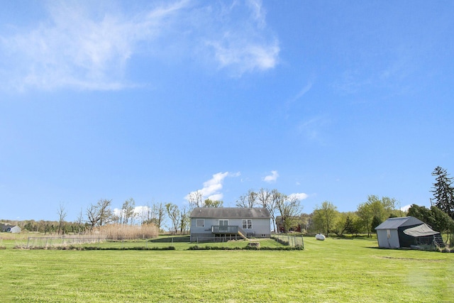 view of yard featuring a rural view, an outdoor structure, and a storage unit