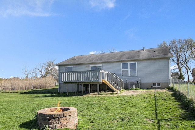 back of property featuring a wooden deck, a fenced backyard, stairs, a lawn, and an outdoor fire pit
