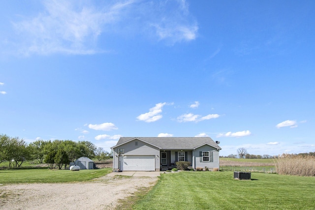 view of front facade featuring a garage, a front lawn, a storage shed, and driveway