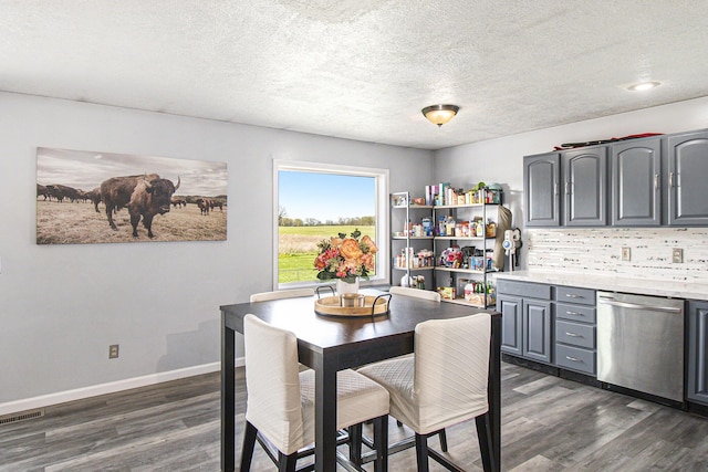 dining space featuring visible vents, a textured ceiling, baseboards, and dark wood-style floors