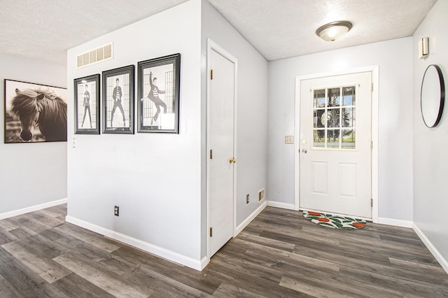 entryway with baseboards, dark wood-style floors, a textured ceiling, and visible vents