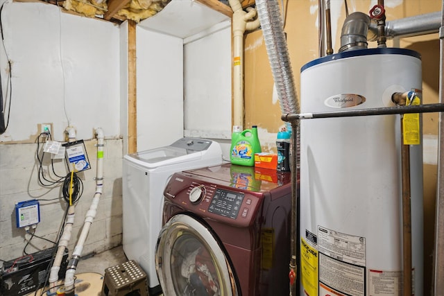 clothes washing area with separate washer and dryer, laundry area, and water heater