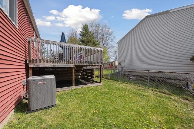 view of yard featuring central AC, a wooden deck, and fence