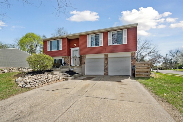 split foyer home with brick siding, a garage, and concrete driveway