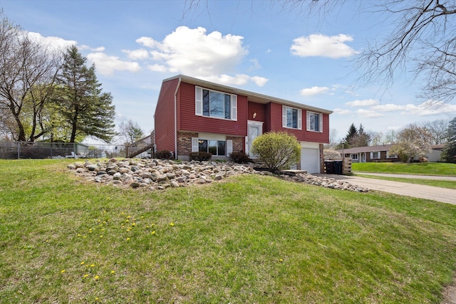 split foyer home featuring fence, driveway, a front yard, and a garage