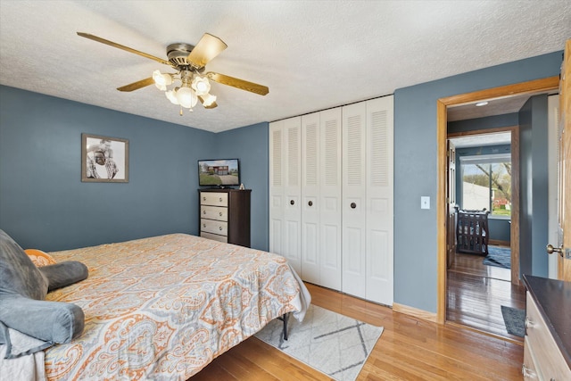 bedroom with a textured ceiling, wood finished floors, and a closet