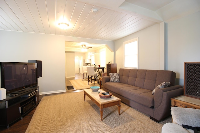 living room with dark wood-style flooring, baseboards, and wood ceiling