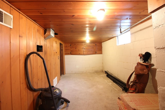 below grade area with visible vents, concrete block wall, and wooden ceiling