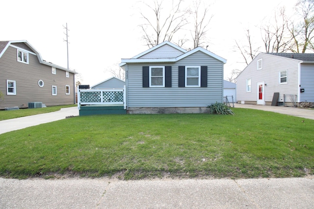 bungalow-style house featuring central AC unit and a front lawn