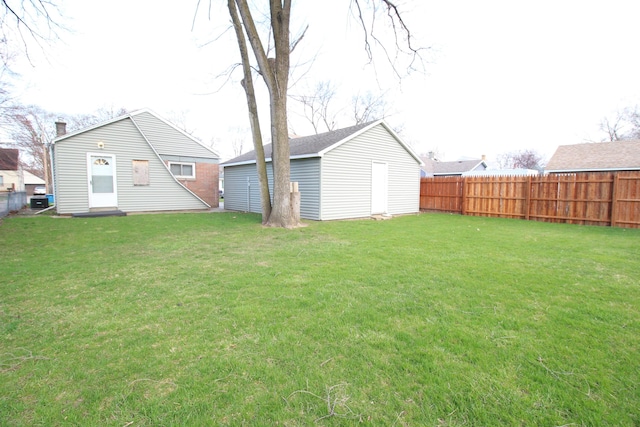 view of yard featuring fence and an outbuilding
