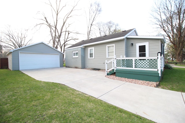 ranch-style home featuring a garage, a front lawn, and an outbuilding