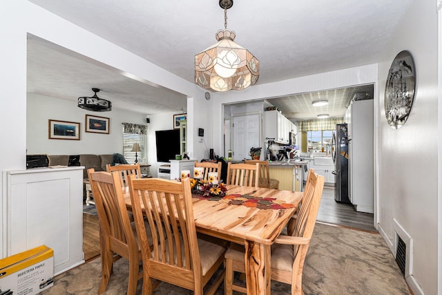 dining area featuring visible vents, light wood finished floors, and a wealth of natural light