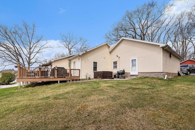 rear view of property with a lawn, a hot tub, a deck, and entry steps