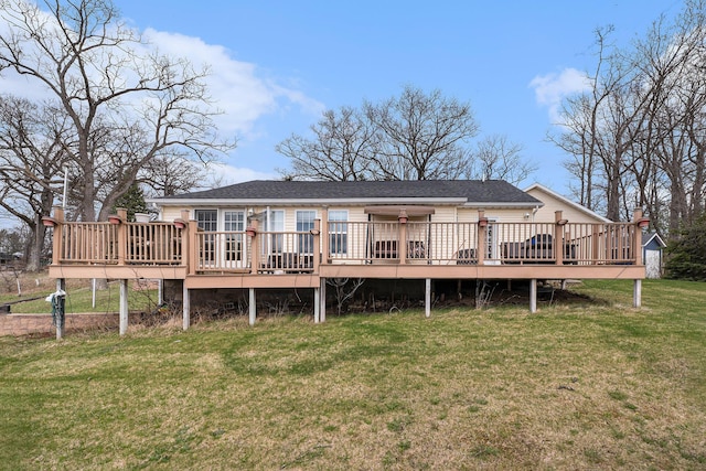 back of property featuring a lawn, a shingled roof, and a deck