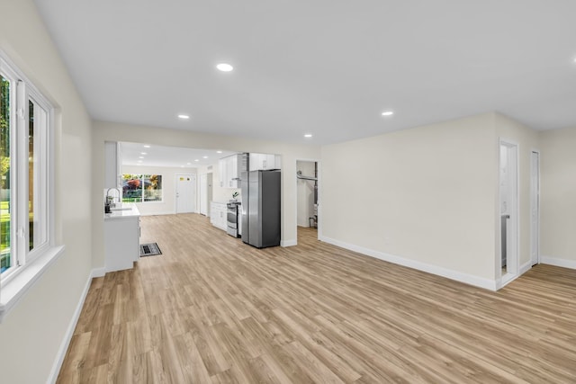 37451 Carpathia Blvd, Sterling Heights, MI 48310 - unfurnished living room featuring baseboards, recessed lighting, light wood-style floors, and a sink