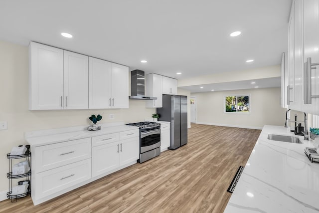 37451 Carpathia Blvd, Sterling Heights, MI 48310 - kitchen featuring wall chimney range hood, white cabinets, a sink, light wood finished floors, and appliances with stainless steel finishes