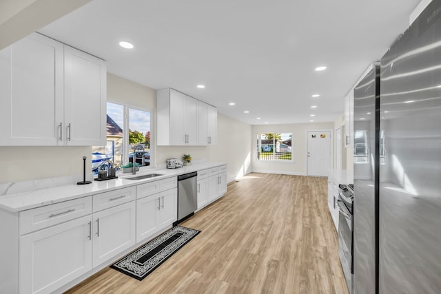 37451 Carpathia Blvd, Sterling Heights, MI 48310 - kitchen with light wood-style floors, appliances with stainless steel finishes, white cabinets, and a sink
