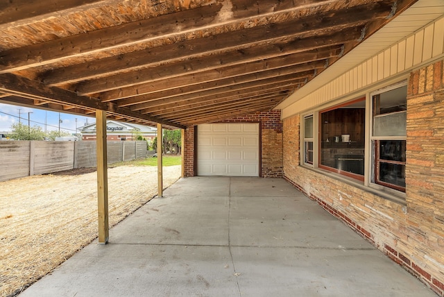 view of patio with concrete driveway and fence