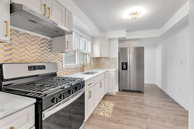 kitchen featuring a sink, white cabinets, stainless steel appliances, and under cabinet range hood