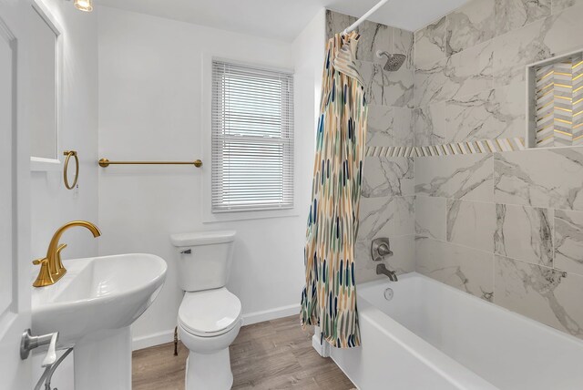 bathroom featuring baseboards, plenty of natural light, toilet, and shower / tub combo