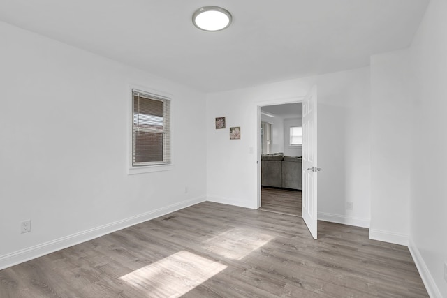 spare room featuring baseboards and wood finished floors