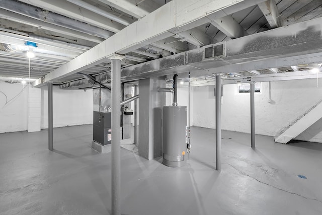 unfinished below grade area featuring visible vents, heating unit, and gas water heater