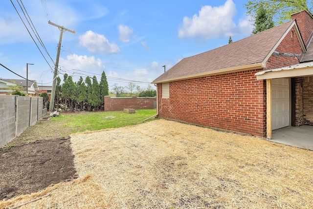 view of yard with fence and an attached garage