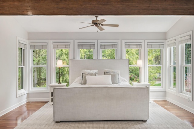 bedroom featuring baseboards, lofted ceiling, and multiple windows