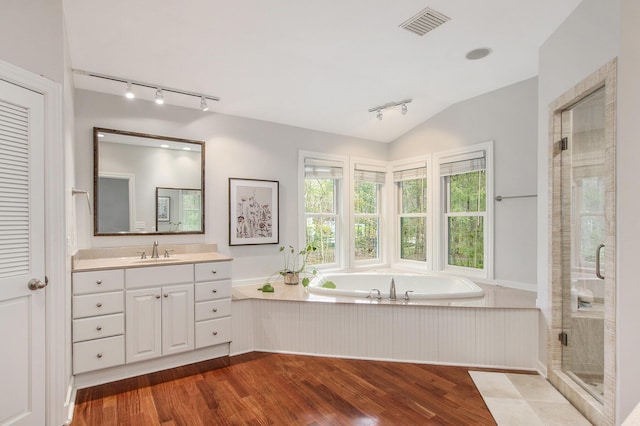 full bathroom with track lighting, vanity, wood finished floors, a bath, and a shower stall