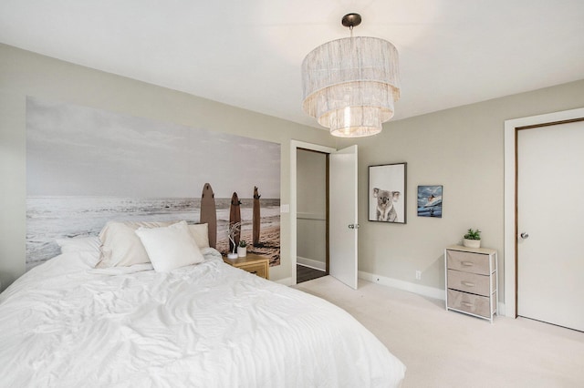 carpeted bedroom with baseboards and an inviting chandelier
