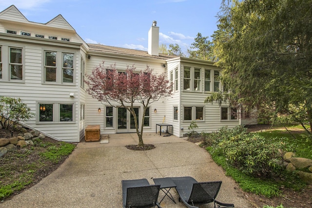 back of property with a patio and a chimney