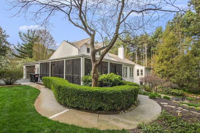 exterior space featuring a chimney and a sunroom