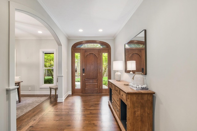 foyer with arched walkways, dark wood finished floors, baseboards, ornamental molding, and recessed lighting