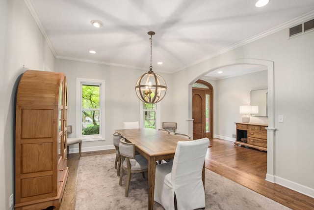 dining space featuring light wood finished floors, arched walkways, a chandelier, recessed lighting, and visible vents
