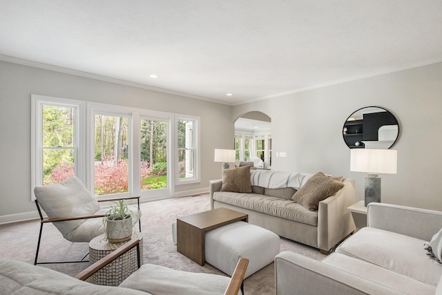 living area featuring crown molding, arched walkways, and baseboards