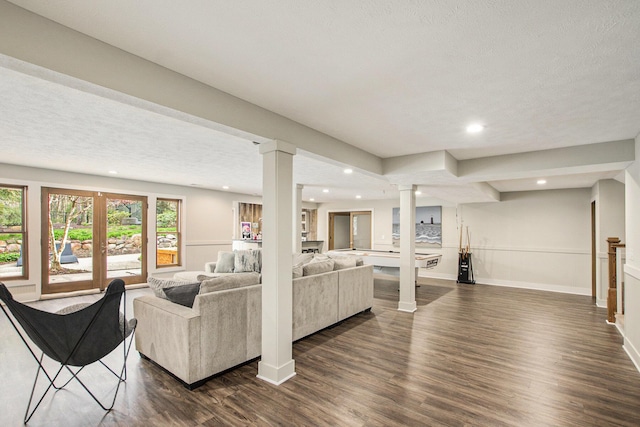 living room featuring recessed lighting, baseboards, decorative columns, and dark wood-style floors