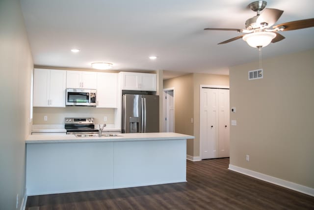 kitchen featuring visible vents, a peninsula, ceiling fan, dark wood-style floors, and appliances with stainless steel finishes