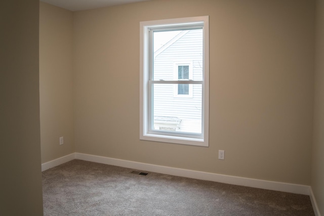 carpeted spare room with baseboards and visible vents