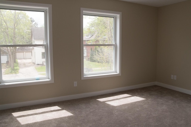 empty room featuring carpet floors and baseboards