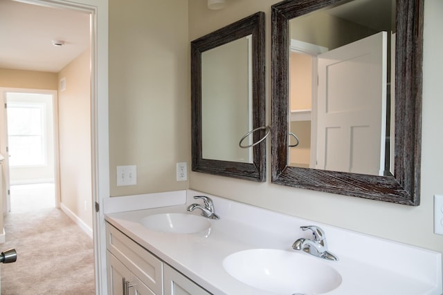 bathroom featuring a sink, baseboards, and double vanity